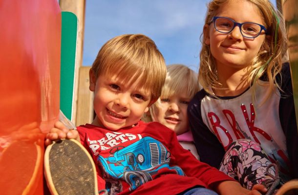 Kinder auf der Rutsche am Spielplatz